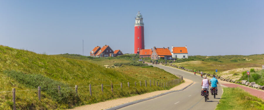 Panorama of a couple riding bicycles on Texel Island, showcasing the scenic landscape of the Netherlands.