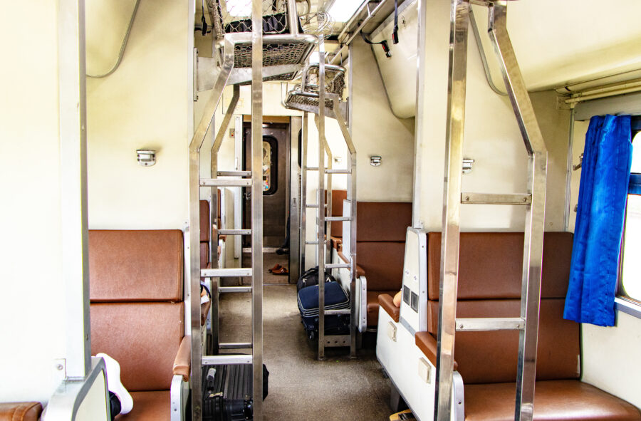 Interior of a Thai sleeper train with air conditioning, showcasing a day and night coach filled with modern amenities.