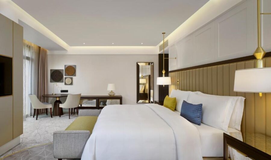 The Alexander hotel room showcases a king bed, desk, and television, offering elegance and comfort in Yerevan.
