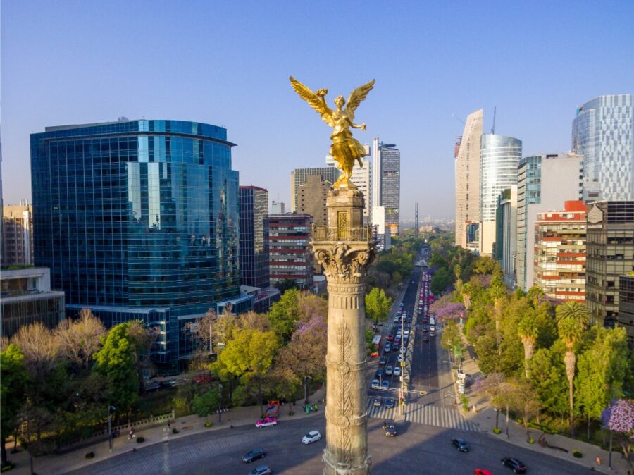 Aerial view of The Angel of Independence monument surrounded by traffic and greenery in Mexico City