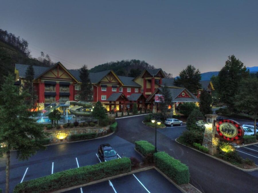 The Appy Lodge in Gatlinburg at night, illuminated with cars parked in front, creating a cozy atmosphere.