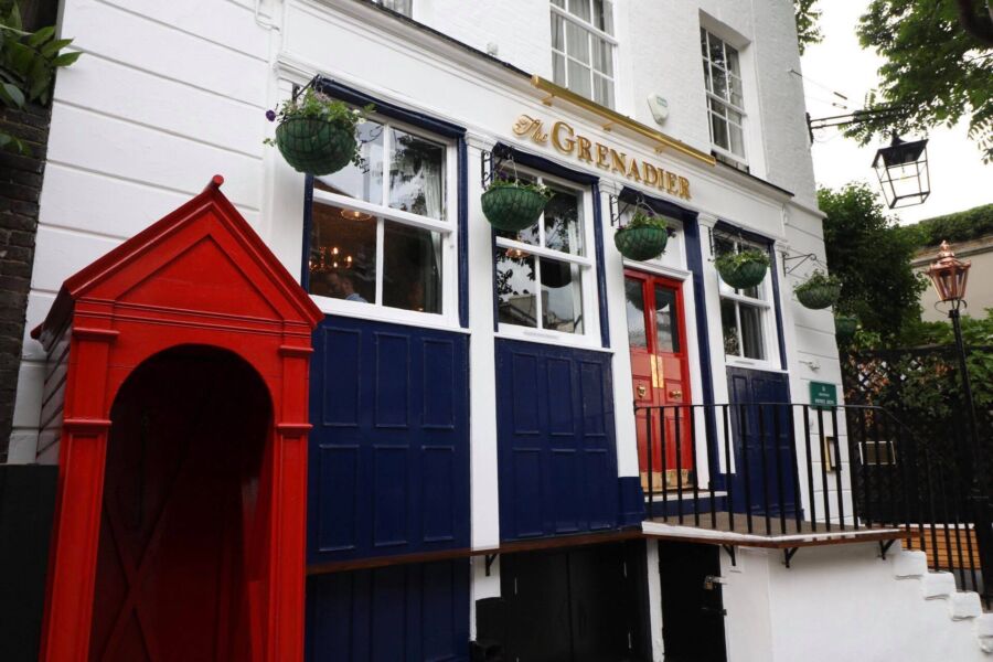 The exterior of The Grenadier Pub, featuring a classic brick facade and inviting entrance
