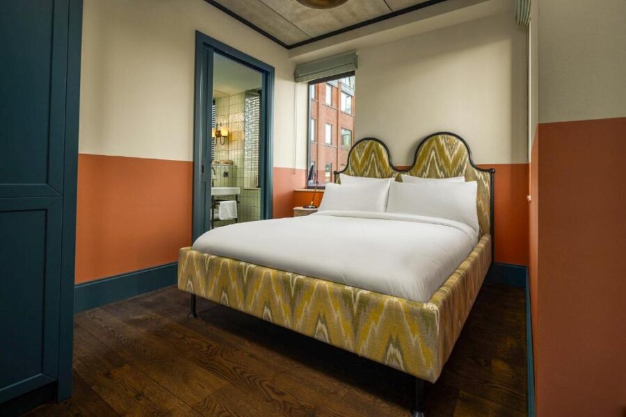 Cozy bed with a colorful bedspread in a stylish room at the July - Boat & Co Amsterdam.