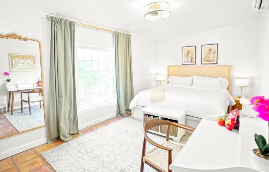 Interior of a bedroom at The Mary Anne Boutique Hotel, showcasing a bed, dresser, and mirror.