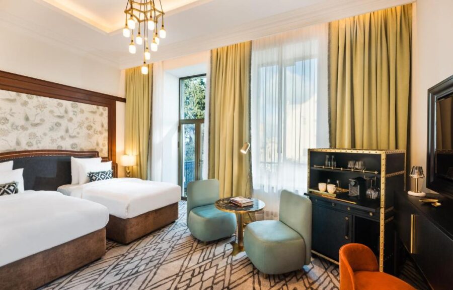 Hotel room at The Merchant Baku featuring two beds and a television, designed for comfort and relaxation.