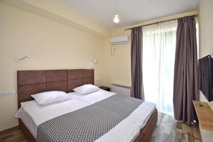 Cozy hotel room at The Nut Guest House in Yerevan, Armenia, featuring a neatly made bed with soft linens.