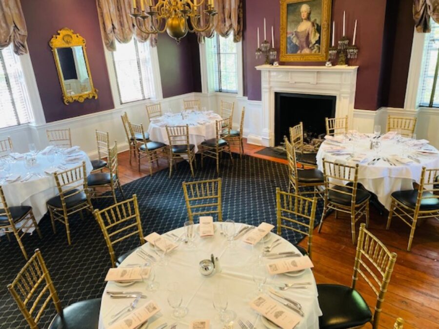 Elegant dining interior of The Olde Pink House in Savannah, featuring antique decor and warm, inviting lighting