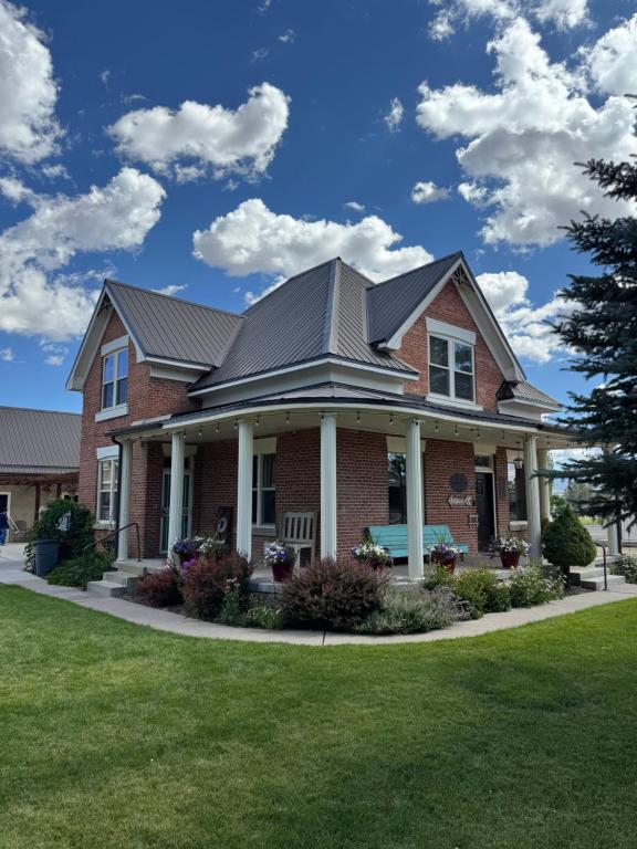 The Panguitch House, a large brick home with a wide porch and a generous yard.