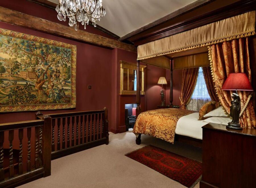 The Rookery in London, UK, showcases a stylish bedroom with a large bed and a beautiful chandelier overhead.