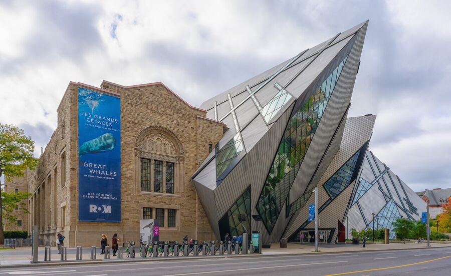 The Royal Ontario Museum features a large triangular glass structure, showcasing modern architectural design.
