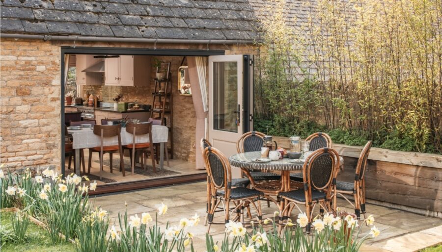 Outdoor dining area at The Ruby Barn, showcasing a table and chairs on a patio in Chipping Norton, Cotswolds.