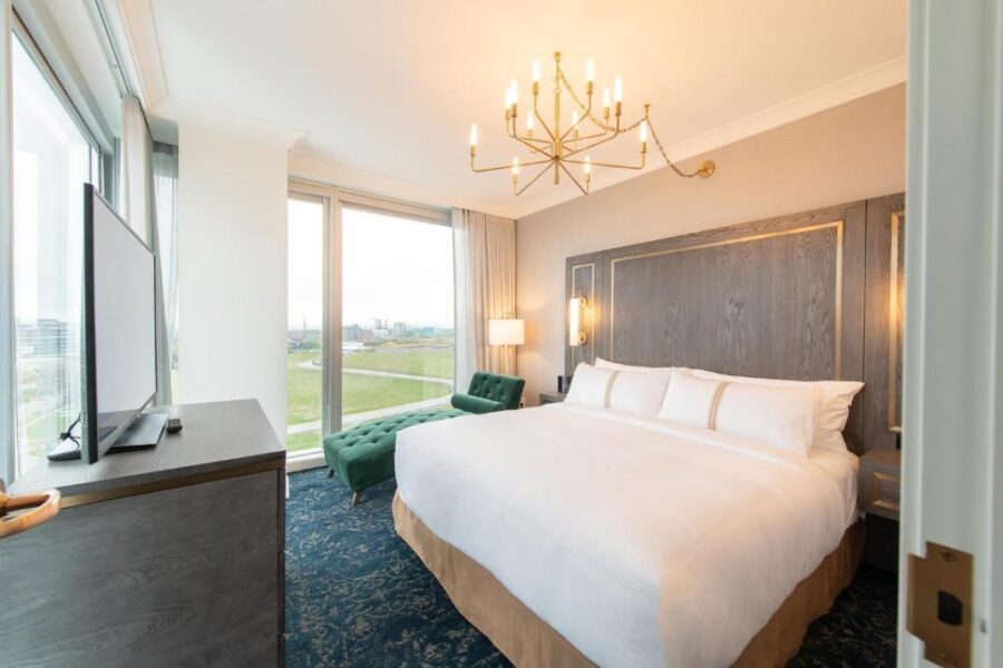 Interior of a hotel room at The Sutton Place Hotel Halifax, showcasing a large bed and a flat-screen television.