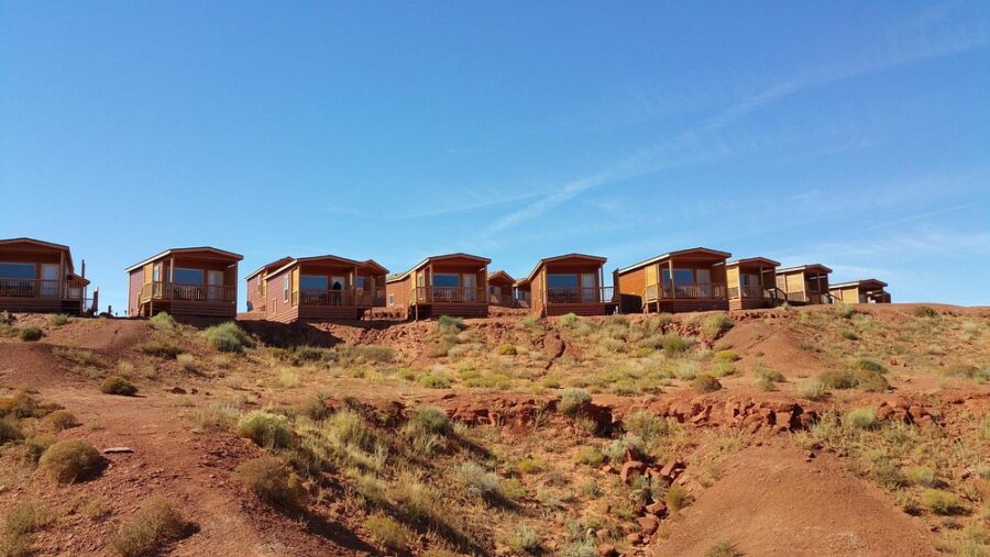Cabins line a hillside at The View Campground, set against the vast desert of Monument Valley.