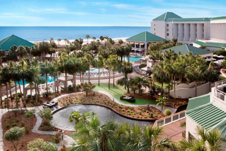 Scenic view of The Westin Hilton Head Island Resort & Spa, with palm trees, a pool, and the beach in the background.

