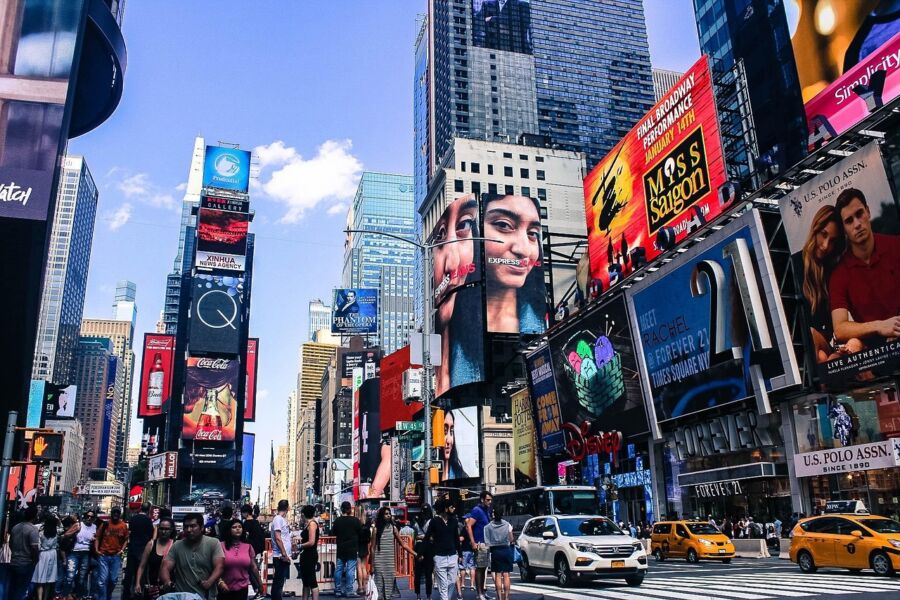 Times Square NYC: bustling crowd, skyscrapers, digital billboards, taxis, culture, commerce, vibrant atmosphere.