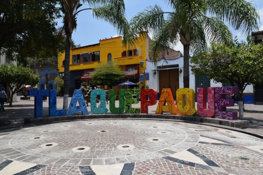 Vibrant Tlaquepaque street scene featuring colorful sign and traditional Mexican architecture.