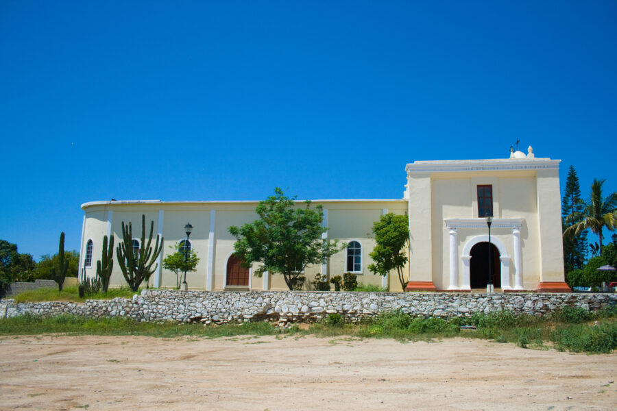 Scenic view of Todos Santos, Baja California Sur, showcasing vibrant buildings and lush landscapes under a clear blue sky 