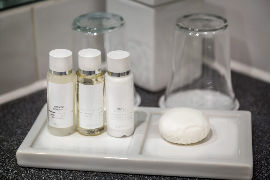 Minimalist bathroom with sleek shampoo, conditioner, body lotion bottles, and handcrafted soap.
