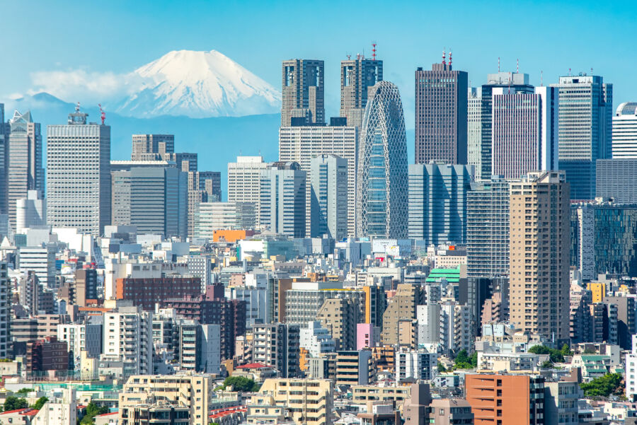 Cityscape of Shinjuku, Tokyo, featuring modern buildings with Mt. Fuji visible in the background