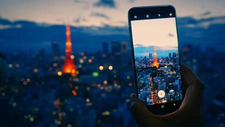 Twilight Tokyo skyline with illuminated Tokyo Tower captured on smartphone.