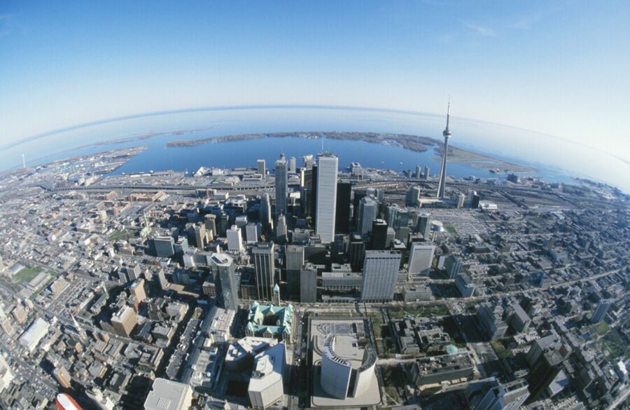Aerial view of Toronto skyline with skyscrapers, Lake Ontario, and vibrant urban landscape.