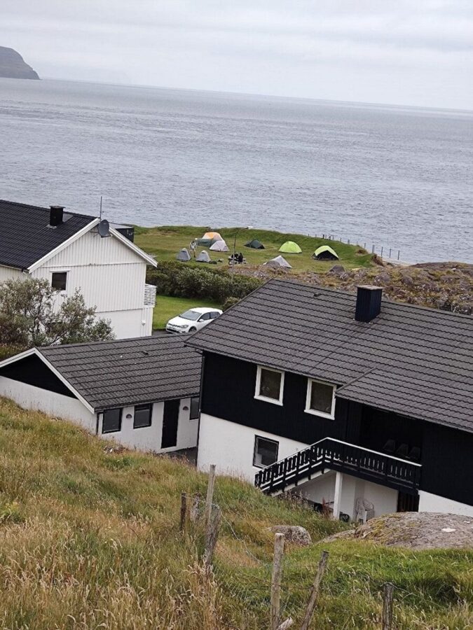 Scenic house perched on a hill, overlooking the ocean, located near Torshavn Camping.