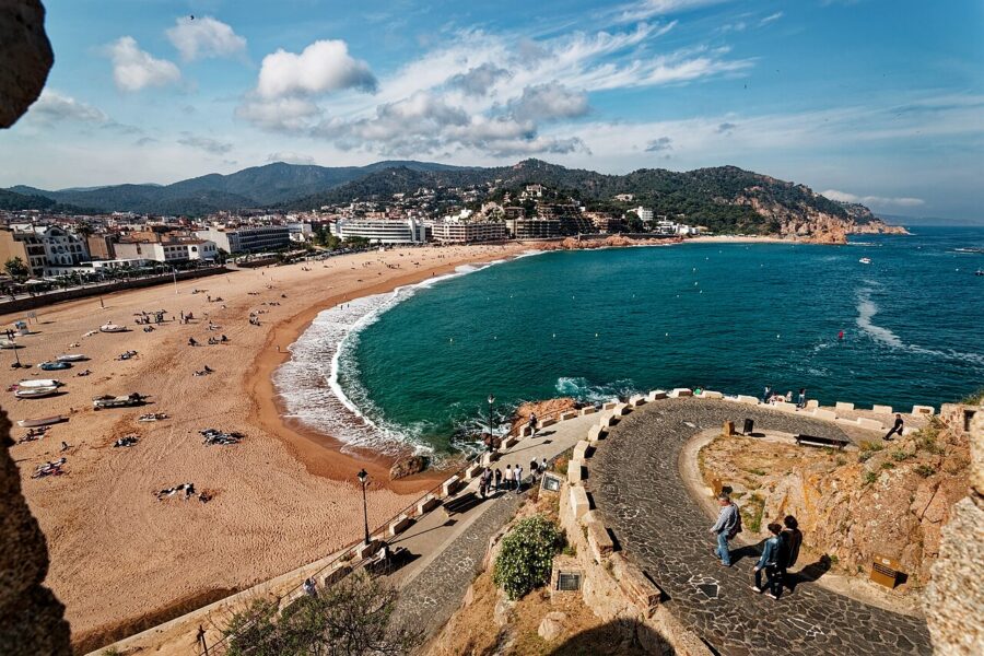 Several boats are moored in a picturesque harbor on the Costa Brava, Spain, reflecting the vibrant coastal scenery.