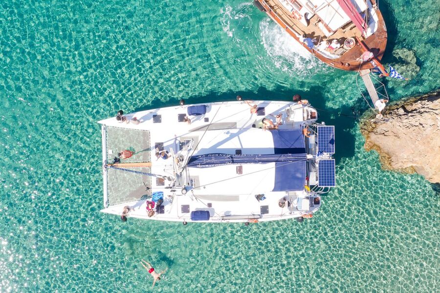 The Kleftiko tour boat is seen floating in the water, with passengers on board admiring the surroundings.
