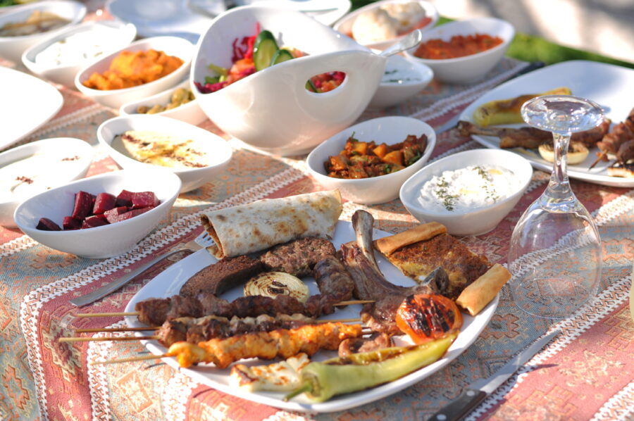 Festive outdoor gathering showcasing traditional Cypriot meze and a selection of flavorful meat and chicken kebabs.