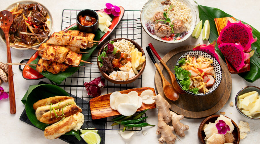 Top view of traditional Indonesian dishes, featuring vibrant colors and various textures on a decorative plate