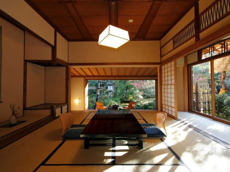 Traditional Japanese tatami room with low table, shoji screens, and garden view at ryokan.