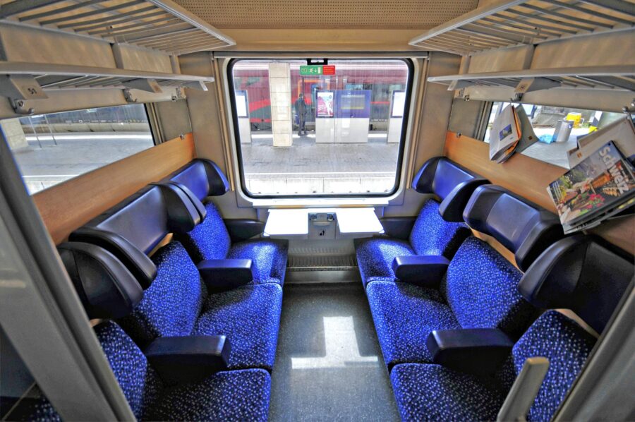 Comfortable EuroNight train interior with plush blue seats and spacious design.