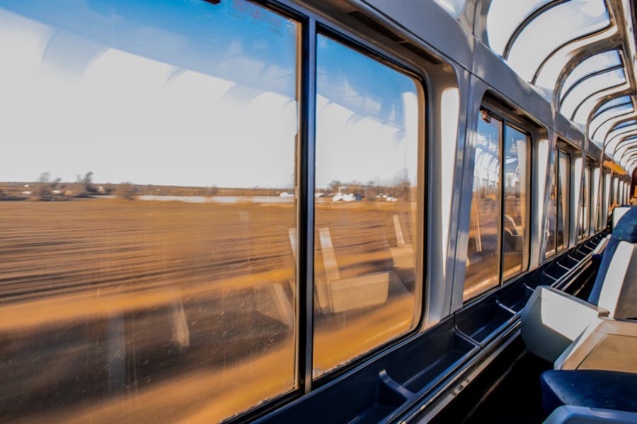 Modern train interior with panoramic windows and scenic landscape view.