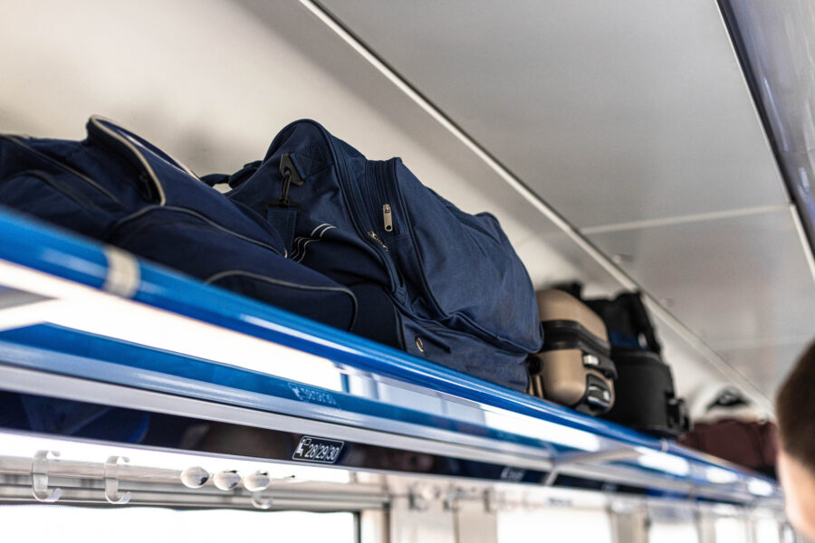 Interior view of a train luggage compartment displaying neatly arranged bags and suitcases for passenger convenience.