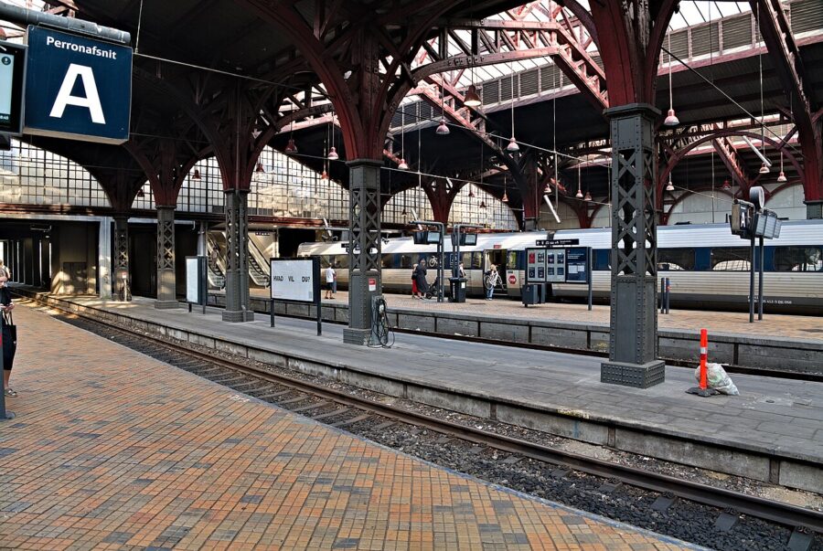 Aarhus Station historic train platform with iron canopy and trains.