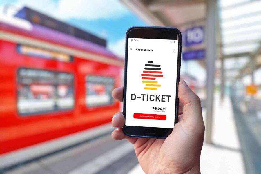 Smartphone displaying Germany train ticket app, €49 digital ticket, red train in background.