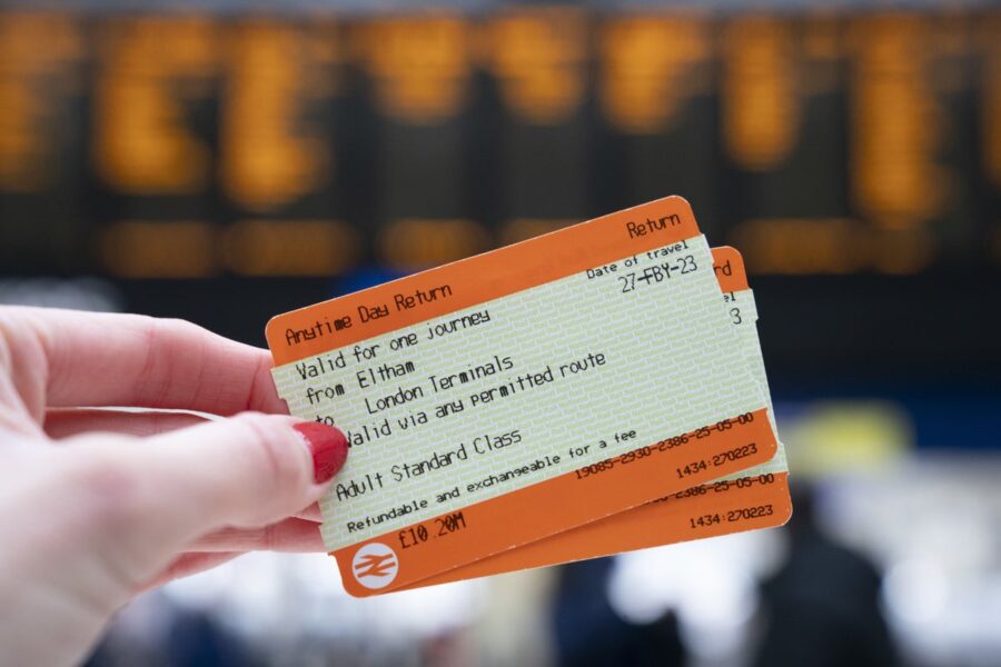 UK train tickets held at station, showcasing travel information and flexible journey plans.