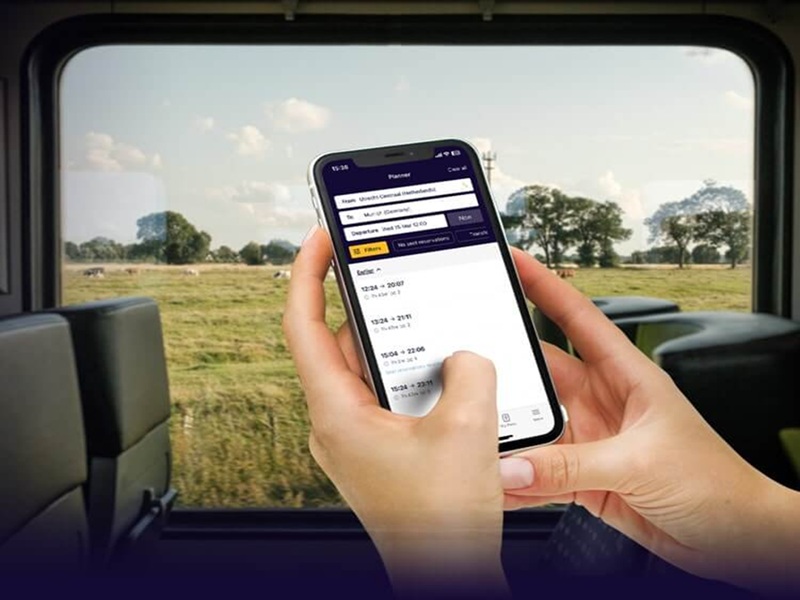 Travel planning on a smartphone inside a serene countryside train journey.