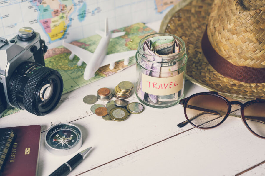 Travel accessories arranged with cash, representing the concept of budgeting for future travel plans and adventures