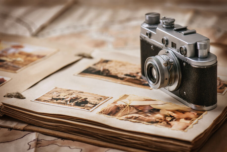 Camera and a photo album are presented together, representing the art of capturing and storing memories