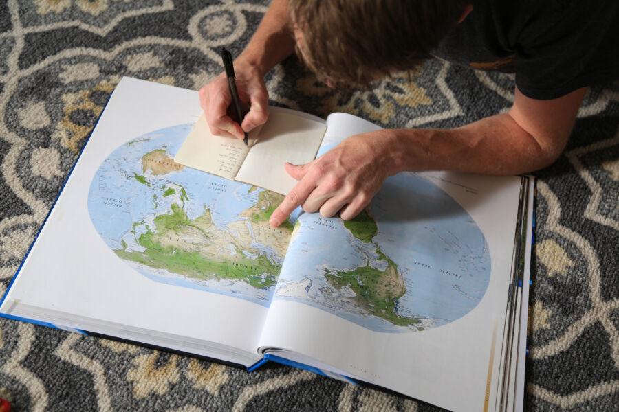 Man compiling a list of places around the world he intends to explore.