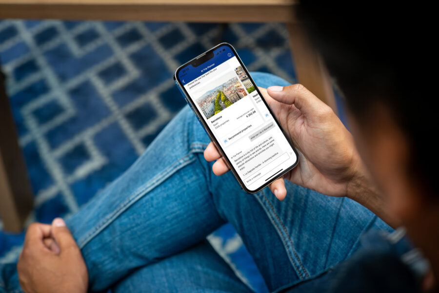 Digital nomad browsing travel accommodations on smartphone in a cozy, modern setting.