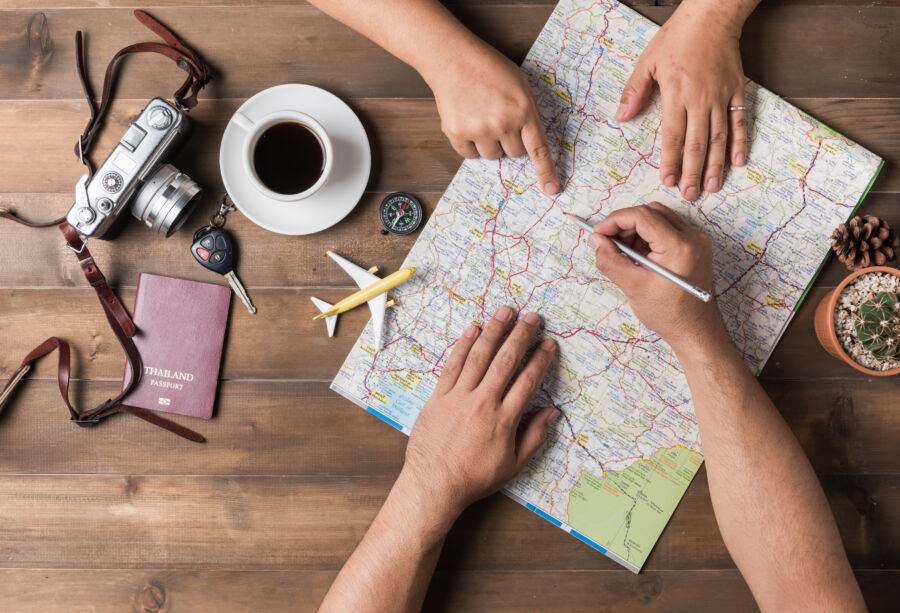 Top view of a young couple studying a map together as they plan their upcoming vacation trip