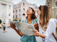 Two female travelers consult a map while exploring the city, seeking directions to their next destination