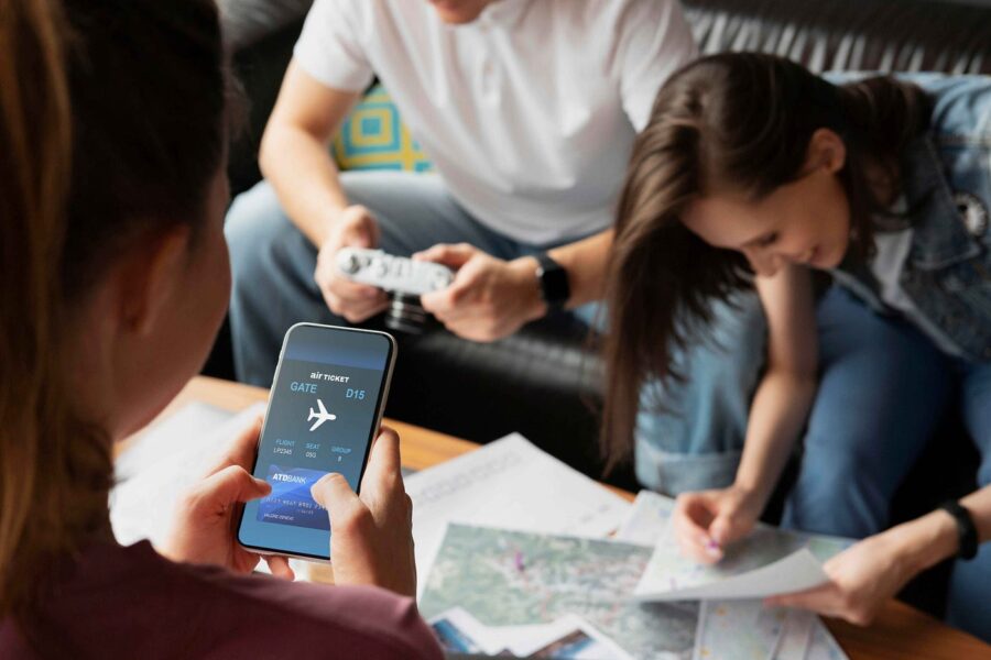 Friends plan travel itinerary with maps, smartphone, and cozy atmosphere.