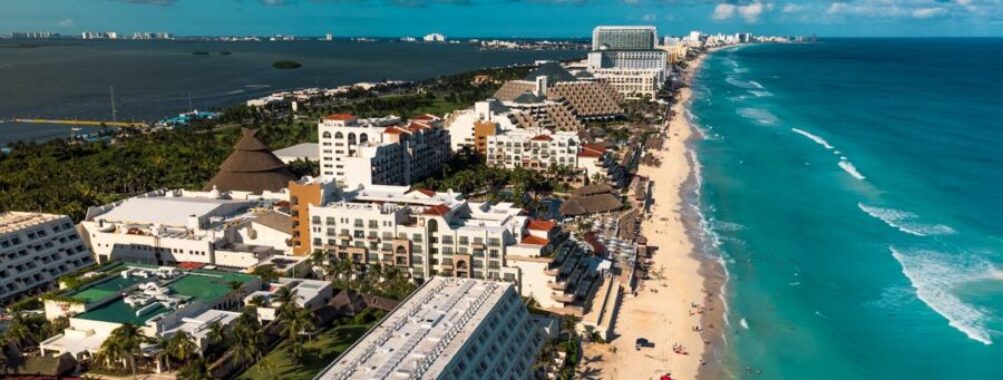 Aerial view of Cancuns tropical beach, hotels, and azure Caribbean Sea.