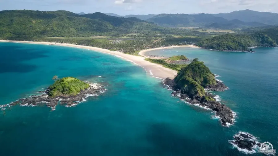 Aerial view of Nacpan Beach tropical coastline with turquoise waters and rocky islets.