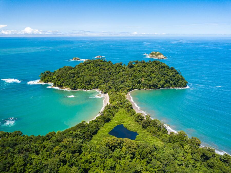 Aerial view of lush tropical island with sandy beaches and vibrant blue waters.