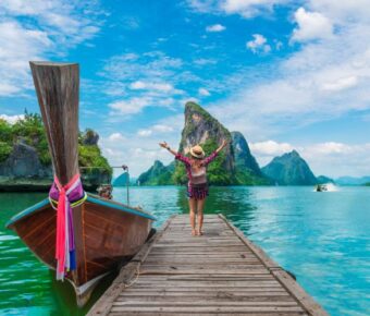 Lady tourist enjoying the scenic views of Phang-Nga Bay in Phuket, surrounded by stunning limestone cliffs and clear waters