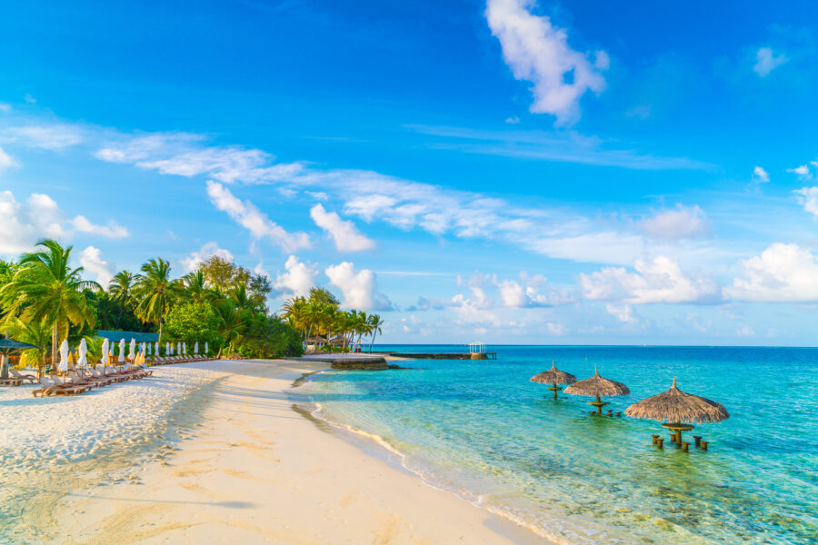 Tropical Maldives island featuring a stunning white sandy beach and clear blue sea under a bright sky